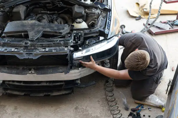 car headlight being replaced by a worker.