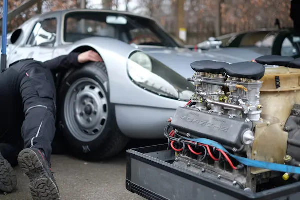 worker inspecting a Porsche.